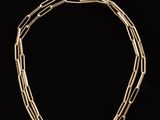 a close up of a gold necklace on a black background