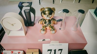 un ours en peluche doré posé sur une table rose