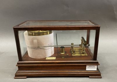 a wooden display case with a barometer inside of it