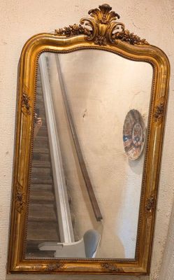 un miroir sur le mur au-dessus d'un lavabo dans une salle de bains