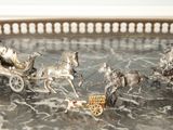 un plateau en argent orné de figurines en argent représentant des chevaux tirant une calèche