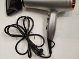 a silver hair dryer and a black cord on a table