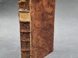 an old book sitting on top of a table next to a gray background