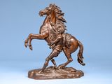 bronze statue of a horse with a rider on it ' s back