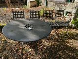 une photo montrant une table et quatre chaises dans le jardin