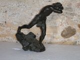 une petite statue représentant un garçon assis sur un rocher