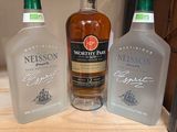 three bottles of liquor are on a shelf with a price tag