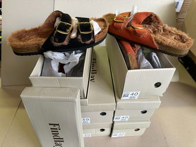 two pairs of shoes that are in boxes on the floor