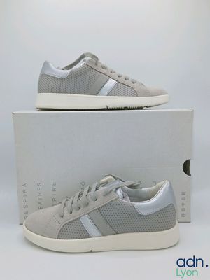 a pair of grey sneakers with white soles on top of a box