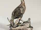 silver plated figurine of a pheasant and a duck on a rock
