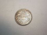 a close up of a silver coin on a white surface