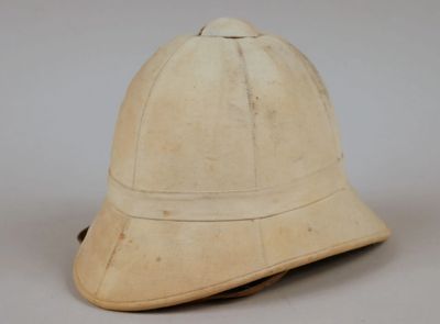 un vieux casque usé repose sur une surface blanche