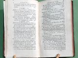 an open book on a table with two wooden sticks sticking out of it