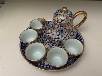 a blue and white tea set on a plate