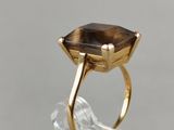 a close up of a gold ring with a brown stone on it