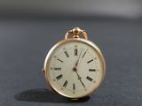une montre de poche en or avec des chiffres romains sur le cadran