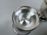 a silver cup sitting on top of a white table