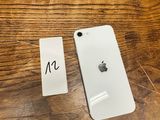 a white iphone sitting on top of a wooden table next to a sticker