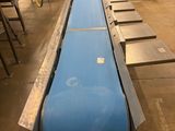 a long blue conveyor belt in a factory