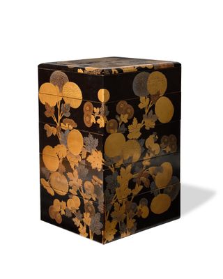 an image of a black and gold box with flowers and leaves on it
