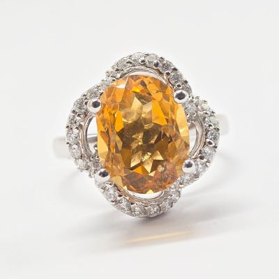 Bague en saphir jaune et diamants sur fond blanc