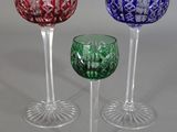 three wine glasses are lined up in a row on a table