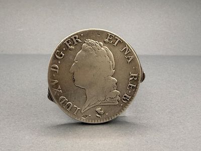 a close up of a coin on a table with a gray background