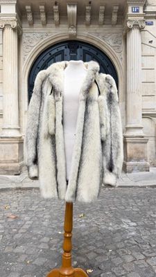 un manteau posé sur un mannequin devant un immeuble