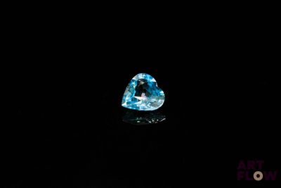 un diamant bleu en forme de cœur sur fond noir