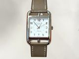 a silver watch with a brown leather strap on a white background