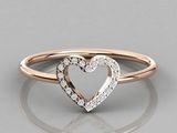a close up of a heart shaped diamond ring on a reflective surface