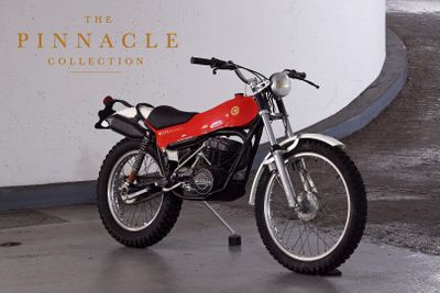 a red motorcycle parked in front of the pinnacle collection sign