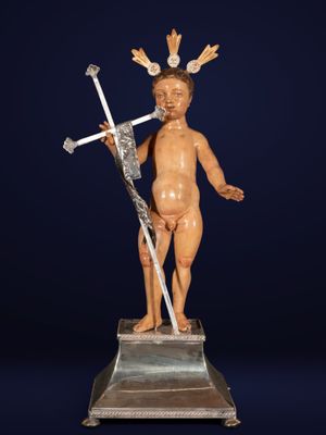 a statue of a child with a crown on his head holding a sword
