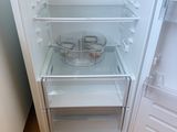 an open refrigerator with a bowl of food inside of it