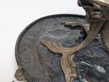 a bronze statue of a fish on a plate