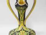 a blue and yellow vase sitting on a white surface