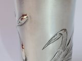 a silver cup with a picture of a bird on it