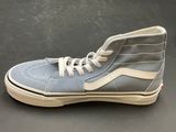 grey and white high top sneakers with white laces on a black surface
