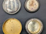 three silver and gold plates with a picture of a woman on them