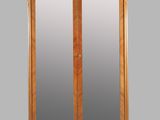 an antique wooden armoire with two mirrors on top of it