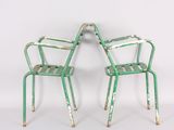 pair of green metal garden chairs against a white background