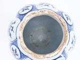 a blue and white vase sitting on a white surface