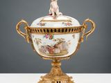 a white and gold bowl with a figurine on top of it