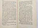an open book with black writing on it sitting on top of a table