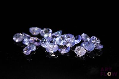 a bunch of purple sapphires on a black surface