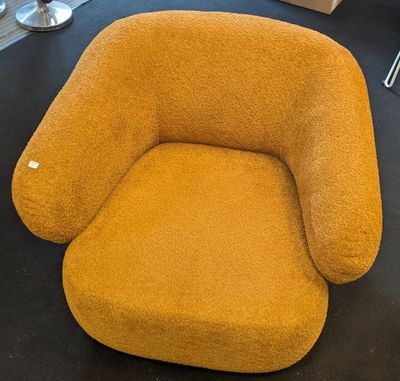 mustard colored chair in a room with a black floor and a black table
