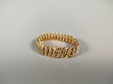 gros plan d'une bague en or sur une surface blanche