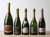 six bouteilles de champagne sont alignées sur une table en bois