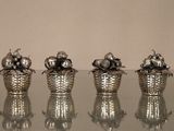 trois vases en argent posés sur une table en verre