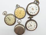plusieurs types de montres de poche sont présentés sur une surface blanche
